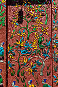 Wat Xieng Thong temple in Luang Prabang, Laos. the Ho Tai, the library. Colourful glass mosaics on a pink background with scenes of daily life. 